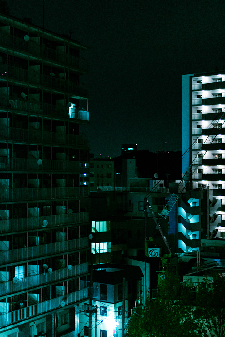 Night time view of a cluster of buildings dimly illuminated from below.